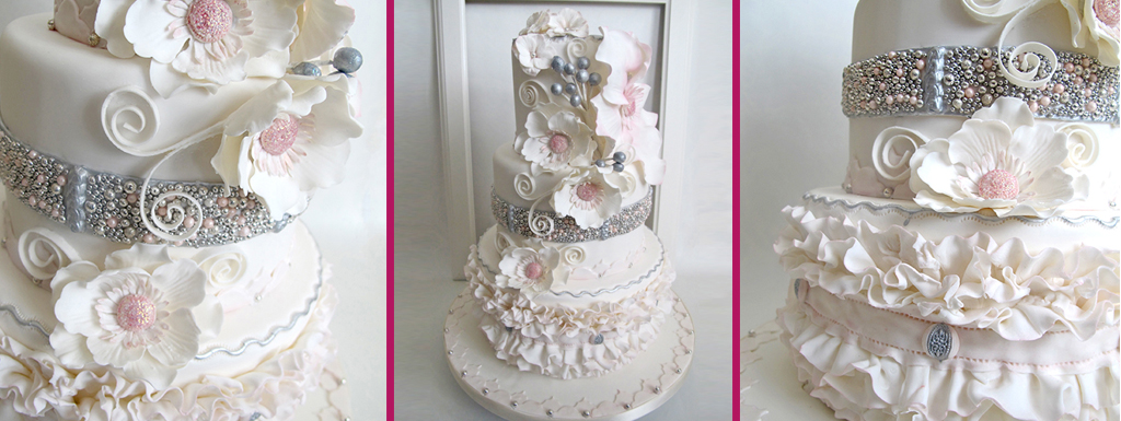 White wedding cake with blush pink and white flowers and silver accents