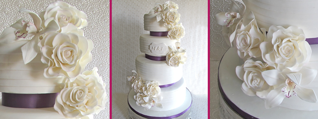 White cake with a layered pattern and White roses and Orchids with purple ribbon